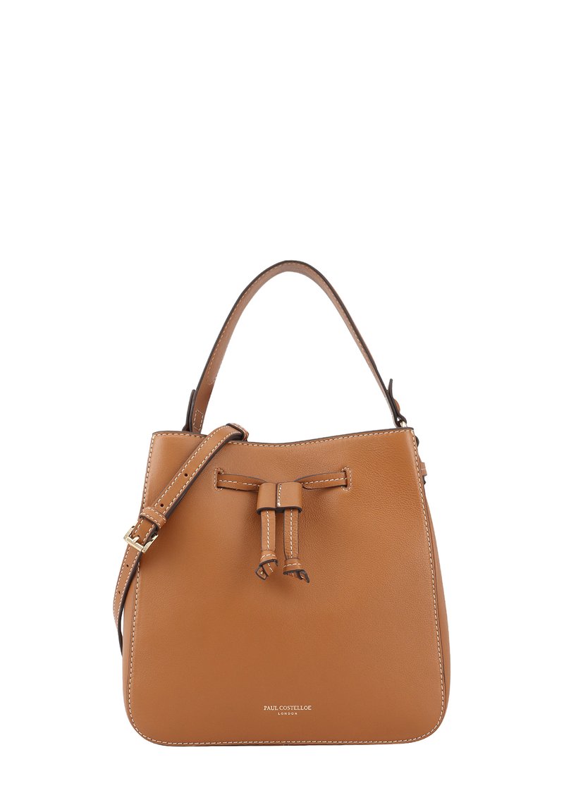 Sac seau en cuir tan avec un haut à cordon, une sangle ajustable et des coutures blanches contrastantes. Présente un logo discret à la base.