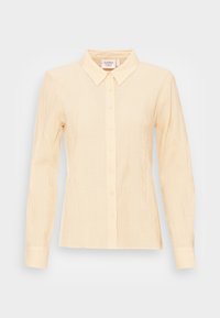 Camisa de botão de manga longa amarelo claro com colarinho pontudo, tecido texturizado subtil e seis botões na frente.