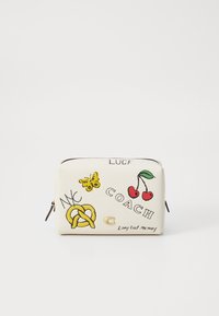 Pochette en cuir blanc avec des motifs brodés colorés, comprenant un papillon, des cerises, un bretzel et des accents de texte "Chance" et "Coach".