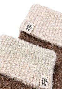 Zwei Wollmützen mit gerippter Textur, eine in Creme und die andere in Braun, die ein kleines Etikett mit einem grafischen Design und Nähdetails aufweisen.