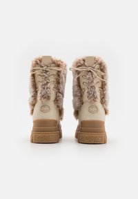 Beige kurpītes ar mežģīnēm, ar mākslīgās vilnas odere, masīvi brūni zoli un logo aizmugurē. Iespējamās dekoratīvās mežģīnes un mīksta virsma.