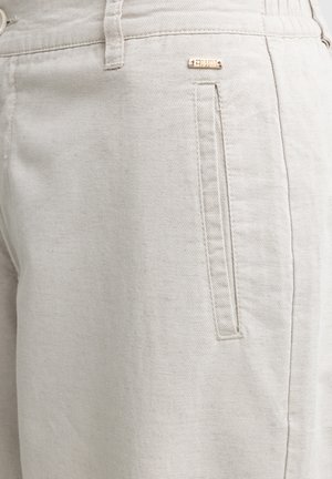 Lichtbeige katoenen broek met een gestructureerd oppervlak, voorzien van een zijzak en een klein gouden logoaccent op de tailleband.