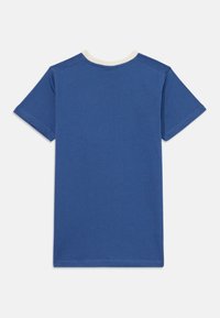 Camiseta de algodón azul con mangas cortas, con un cuello redondo beige. Textura suave con dobladillos cosidos y un diseño liso en la parte posterior.