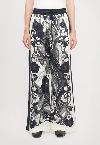 Pantalons en lin à jambes larges avec un motif floral noir sur fond blanc, dotés d'une taille élastique et d'une fermeture à cordon.