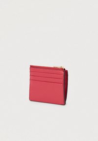 Rødt læderpung med tekstureret overflade, har fire kortlommer og et rum med lynlås, fremhævet med kontrasterende sort syning.