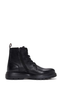 Botas de cuero negro hasta el tobillo con cordones, cremallera lateral, acabado texturizado y suela de goma gruesa. Cuenta con una lengüeta trasera para un fácil calzado.