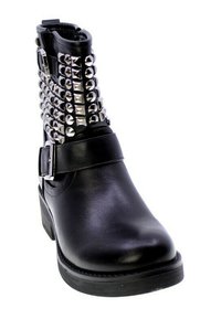 Stivale alla caviglia in pelle nera con tacco spesso, dotato di borchie a piramide argentate lungo il lato, una cintura con fibbia attorno alla caviglia e una texture liscia.