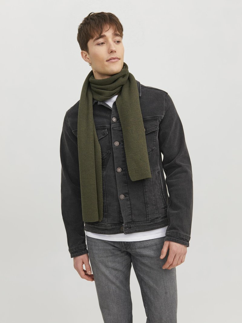 Sciarpa di lana di colore verde oliva avvolta attorno al collo, abbinata a una giacca di denim nera e jeans grigi. Design semplice e texturizzato.