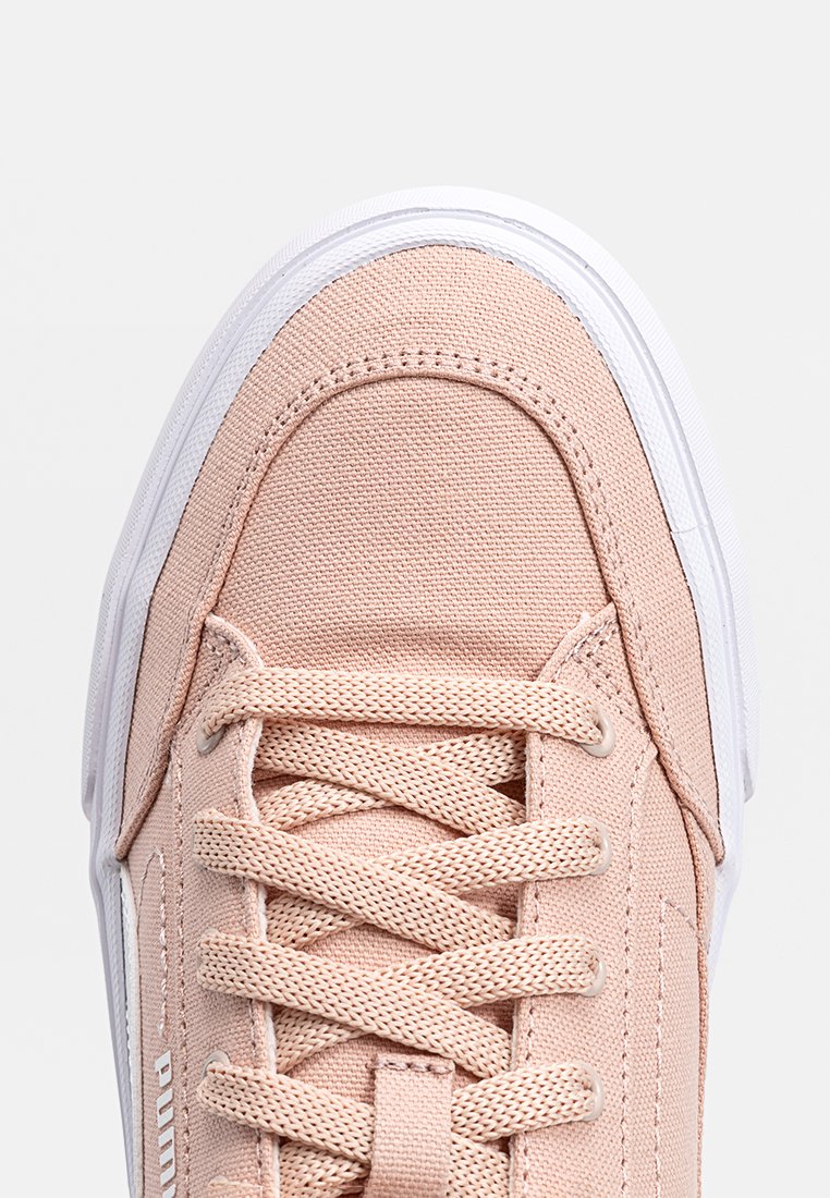 Lichtroze canvas sneaker met een witte rubberen zool, voorzien van ronde veters, een versterkte teencap en subtiele branding aan de zijkant.
