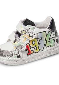 Sneaker bianco con accenti neri, caratterizzato da fascette in Velcro e grafiche in stile graffiti colorate, inclusi i numeri "1974" e motivi a stella.