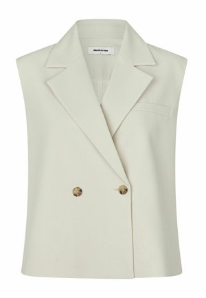 Bez piedurknēm šampanieša krāsas žakete ar platajiem atlokiem, dubultā rinda ar brūniem pogām, krūšu kabatu un Modström etiķeti apkakles iekšpusē.