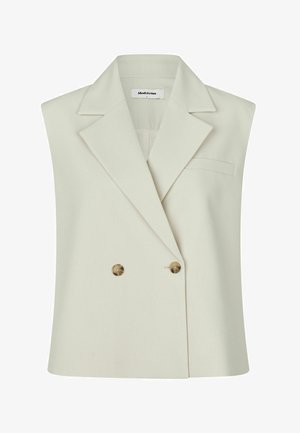 Besiūlis smėlio spalvos švarkas be rankovių su plačiais atlapais, dvigubo sagstymo rudos spalvos sagomis, krūtinės kišene ir Modström etikečių ant apykaklės viduje.