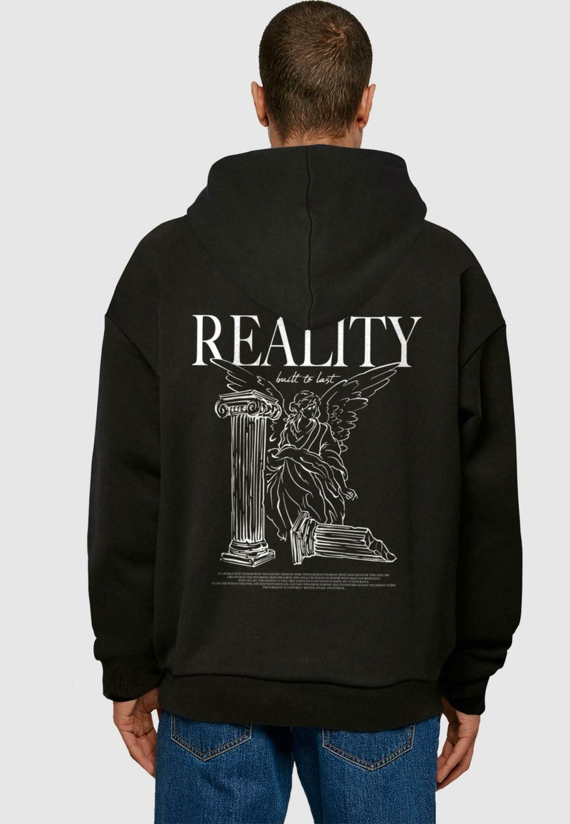 Čierna mikina s kapucňou, na zadnej strane s veľkým bielym grafickým dizajnom, znázorňujúca anjela pri stĺpe, s nápisom "REALITY built to last".