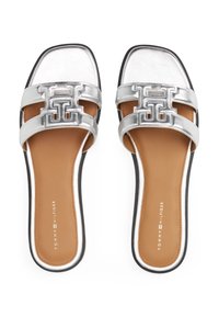 Sølvmetallic slide sandaler med firkantet tå, to brede stropper med et geometrisk logo og en brun polstret sål med sort ydersål.