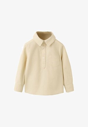 Otroški dolg rokav majica v krem barvi z ovratnikom, sprednjim žepom in zapiranjem na dva gumba.