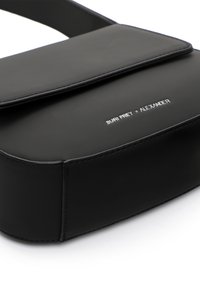Bolso bandolera negro con textura suave, cierre de solapa y herrajes plateados que presentan la marca "SURI FREY x ALEXANDER".