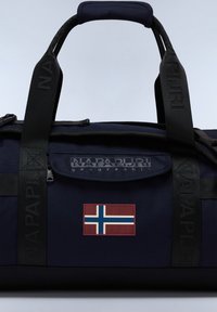 Tmavě modrá taška přes rameno s kapsou na zip, popruhy s logem "NAPAPIJRI" a nášivkou norské vlajky na přední straně. Texturovaný povrch látky.