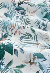 Floralni materijal s zelenim listovima, plavim cvjetovima i bež detaljima na svijetloplavoj pozadini. Glatka tekstura s živopisnim, botaničkim uzorkom.