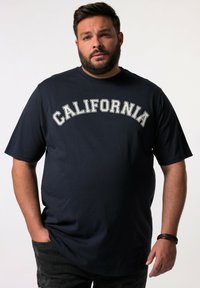 Námořnická modrá bavlněná tričko s nápisem "CALIFORNIA" v bílém zakřiveném písmu. Krátké rukávy, kulatý výstřih, volný střih, hladká textura.