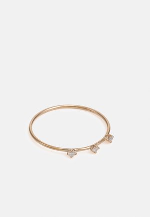 Goldring mit einem dünnen Band und drei kleinen Kristallakzenten im Krappen-Design, das eine minimalistische und elegante Ästhetik präsentiert.