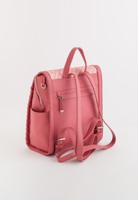 Mochila de piel rosa con parte superior trenzada, compartimentos con cremallera, correas ajustables y bolsillo lateral. Presenta una textura trenzada en un lado.