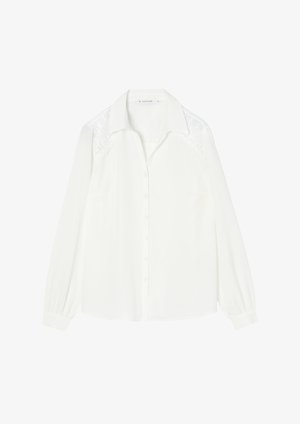 White long-sleeve blouse with a classic collar, front button closure, and textured lace detailing on the shoulders. Smooth fabric finish.
