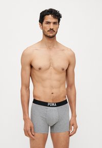 Szürke boxer alsónadrág fekete rugalmas derékpánttal, rajta fehér "PUMA" logóval. A szövet lágy és sima tapintású.
