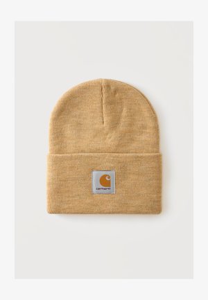 Svetlohnedá pletená čiapka s preklopeným lemom a štvorcovou nášivkou v strede vpredu s názvom značky Carhartt.