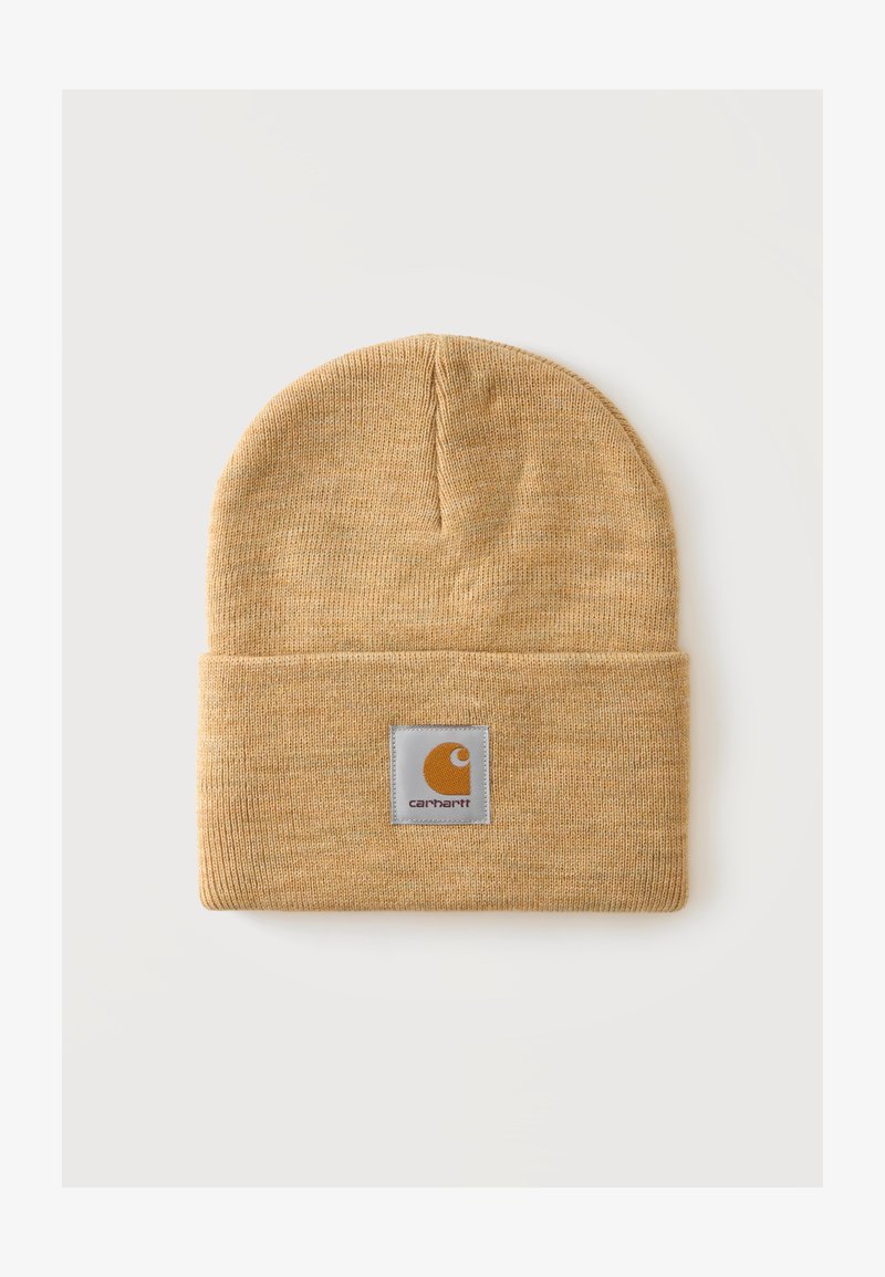 Bonnet en maille marron clair avec bord-côte replié et écusson carré au centre devant affichant le nom de la marque Carhartt.