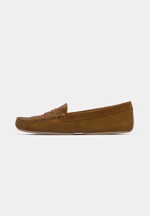 Mocassini in suede marrone con una cucitura, suola piatta e punta arrotondata. Design semplice caratterizzato da una piccola fascia decorativa sulla parte anteriore.
