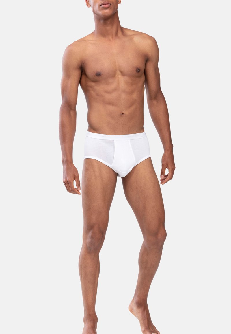 Boxer in cotone bianco con una vestibilità attillata, caratterizzati da un logo sulla cintura e una texture liscia. Il modello presenta un fisico atletico.
