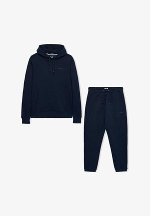 Navyblauwe hoodie en bijpassende joggingsbroek van zacht materiaal. Bevat een voorzak en een trekkoord in de taille voor de broek.