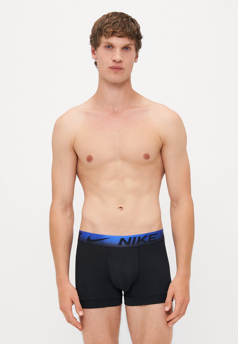 Czarne bokserki z niebieskim logo Nike na pasku. Gładki materiał, dopasowany krój, niskie osadzenie i minimalistyczny styl.