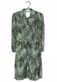 Grünes Schlangenledermuster-Kleid mit langen Ärmeln, Knopfleiste und weichem Stoff. Hängt an einem schwarzen Haken und zeigt seinen lockeren Schnitt.