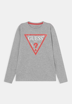 Chemise grise à manches longues avec un logo triangulaire rouge indiquant "GUESS U.S.A." et un point d'interrogation rouge au centre à l'avant.