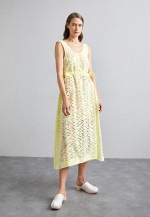 Gelbes Spitzenkleid mit Rundhalsausschnitt, Ripsband in der Taille und einem fließenden Schnitt. Verfügt über strukturierte Muster, mehrlagiges Design und ist knöchellang.