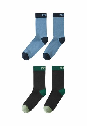 Zwei Paare von Crew-Socken, eine blau mit dunkelblauen Zehen, Fersen und Bündchen, und eine schwarz mit grünen Zehen, Fersen und Bündchen, beide mit teilweise bedruckten Bündchen.
