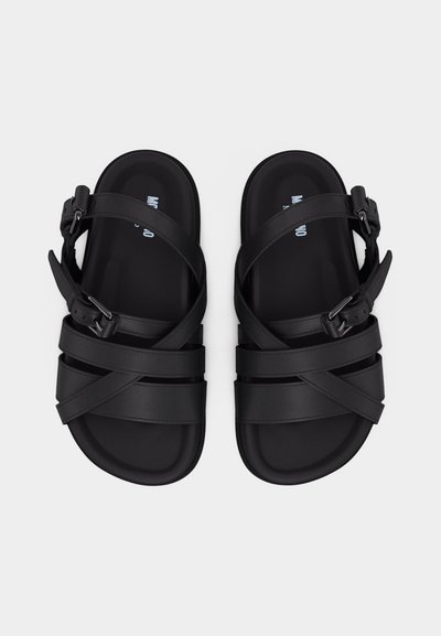 Ζευγάρι μαύρων δερμάτινων σανδαλιών με πολλαπλούς ιμάντες και ρυθμιζόμενες αγκράφες, απεικονισμένα από πάνω σε λευκό φόντο.