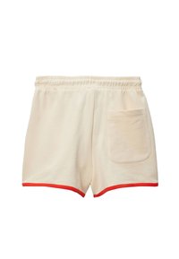 Shorts en coton crème avec une texture douce, dotés d'un ourlet rouge et d'une poche arrière unique pour plus de fonctionnalité.