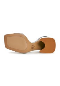 Scarpa con tacco, dotata di una tomaia bianca liscia e una suola in gomma marrone ampia. Presenta un cinturino stretto e un design del tacco semi-quadrato.