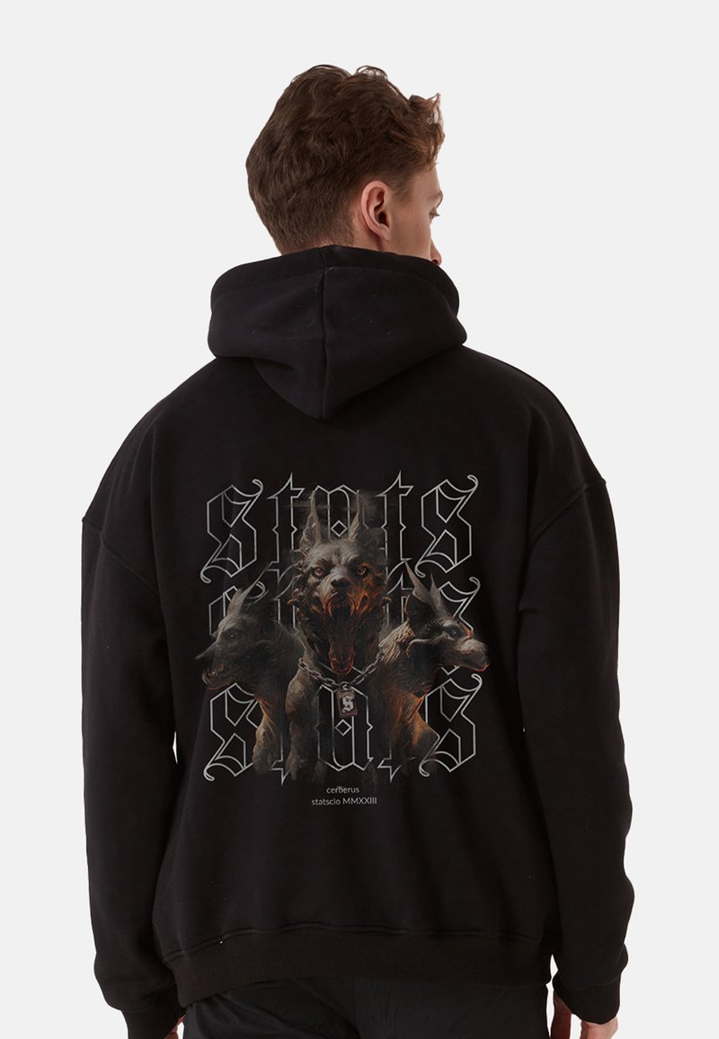 Black hoodie featuring a graphic of three dogs, one in front with a fierce expression. Includes stylized text and a chain design.