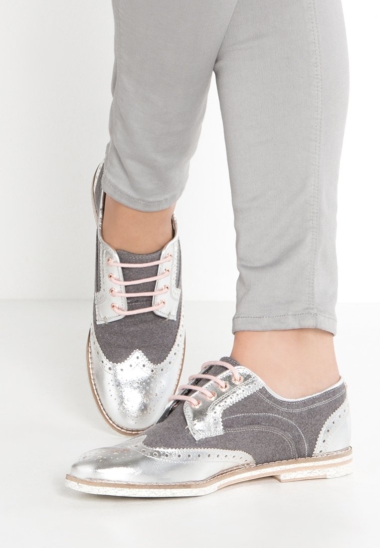 Chaussures à lacets grises et argentées avec un dessus en textile gris texturé, un bout en métal argenté brillant et des lacets roses ; ornées d'accents perforés.