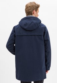 Marineblaues Kapuzenshirt mit geradem Schnitt, aus strukturiertem Stoff; hat eine Rückenpasse und lange Ärmel. Keine sichtbaren Hardware-Details.
