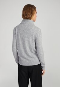 Maglione grigio a maglia con colletto alto, orlo e polsini a costine, caratterizzato da una texture morbida. La parte posteriore presenta una vestibilità rilassata e una superficie liscia.