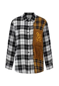 Chemise à carreaux noir et blanc avec un panneau jaune moutarde orné de franges et de texte brodé. Style boutonné, manches longues.