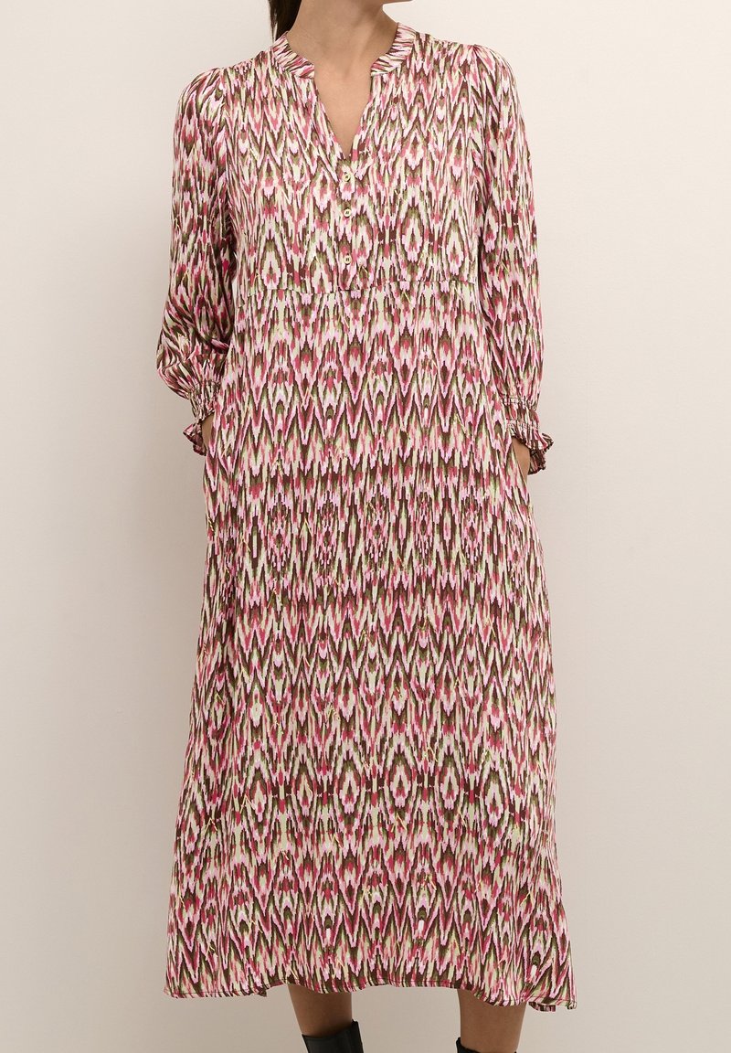 Maxi dress in a pink and green geometric pattern, featuring a buttoned neckline, long sleeves, and gathered detailing at the waist.