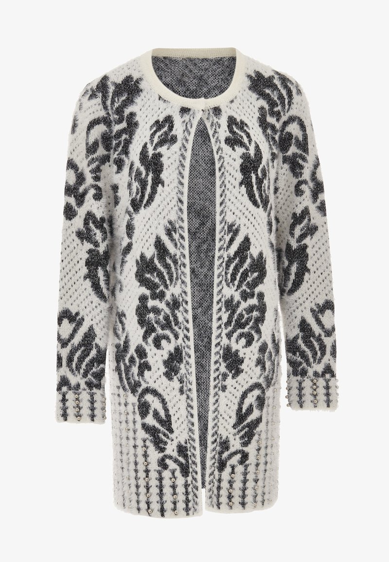 White and black patterned long cardigan with a fuzzy texture, open front, and decorative studs on the cuffs. Features intricate floral design.