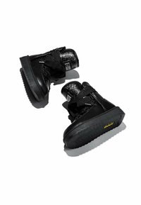 Zapatillas altas negras de cuero y materiales sintéticos, con acentos texturizados, suela gruesa de goma negra y cordones planos.