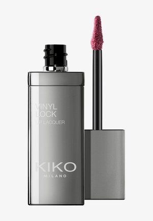 Harmaa suorakulmainen pullo, jossa on etiketti "VINYL LOCK LIP LACQUER", musta applikaattori ja teksturoitu vaaleanpunainen huulituote kärjessä.