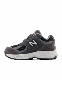 Chaussure de sport grise en matériaux mesh et suède, offrant une semelle moulée, une sangle ajustable et un logo 'N' bien visible sur le côté.